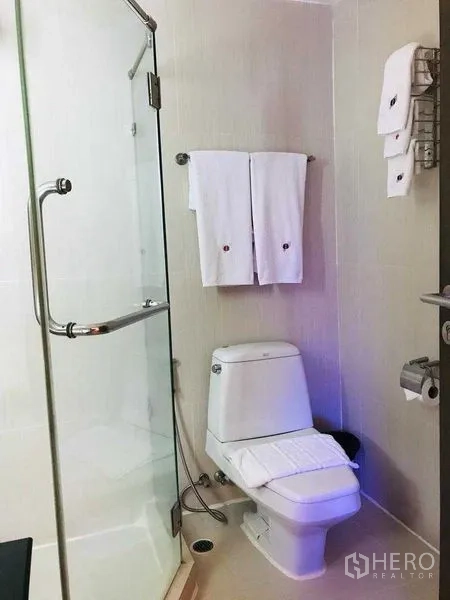 Shophouse for rent in Watthana, Bangkok - Compact bathroom with toilet, towels and glass shower
