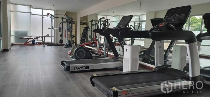 Condominium for sale in Pathum Wan, Bangkok - Condo fitness room with treadmills, weight machines and full-wall mirrors in Pathum Wan.