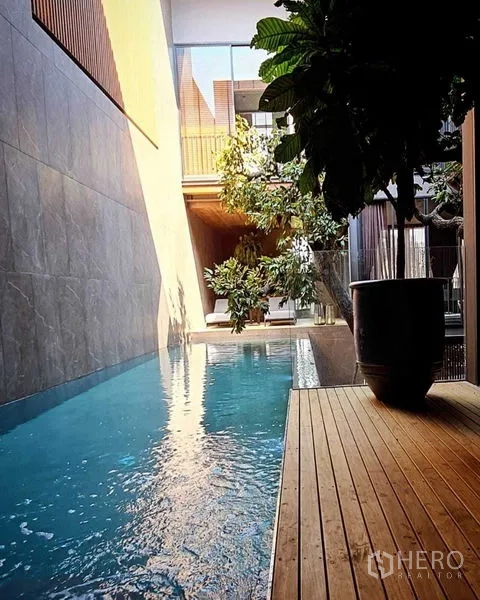 บ้าน ขายในLat Phrao, Bangkok - สระว่ายน้ำแบบลาปขนานดาดไม้และต้นไม้ ได้แสงบ่าย