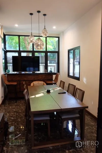 Detached House for rent in Bang Phli, Samut Prakan - Dining room with long wooden table, pendant lights and large windows.