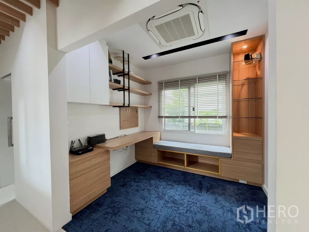 Detached House for rent or sale in Khlong Luang, Pathum Thani - Home office with L-shaped desk, floating shelves and a window seat.