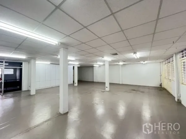 Shophouse for rent in Phra Khanong, Bangkok - Bright upper-floor room with support pillars and a long line of windows.