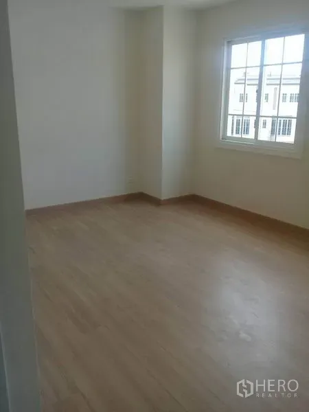 Home Office for rent in Bang Na, Bangkok - Corner bedroom with a large window and wood laminate flooring.
