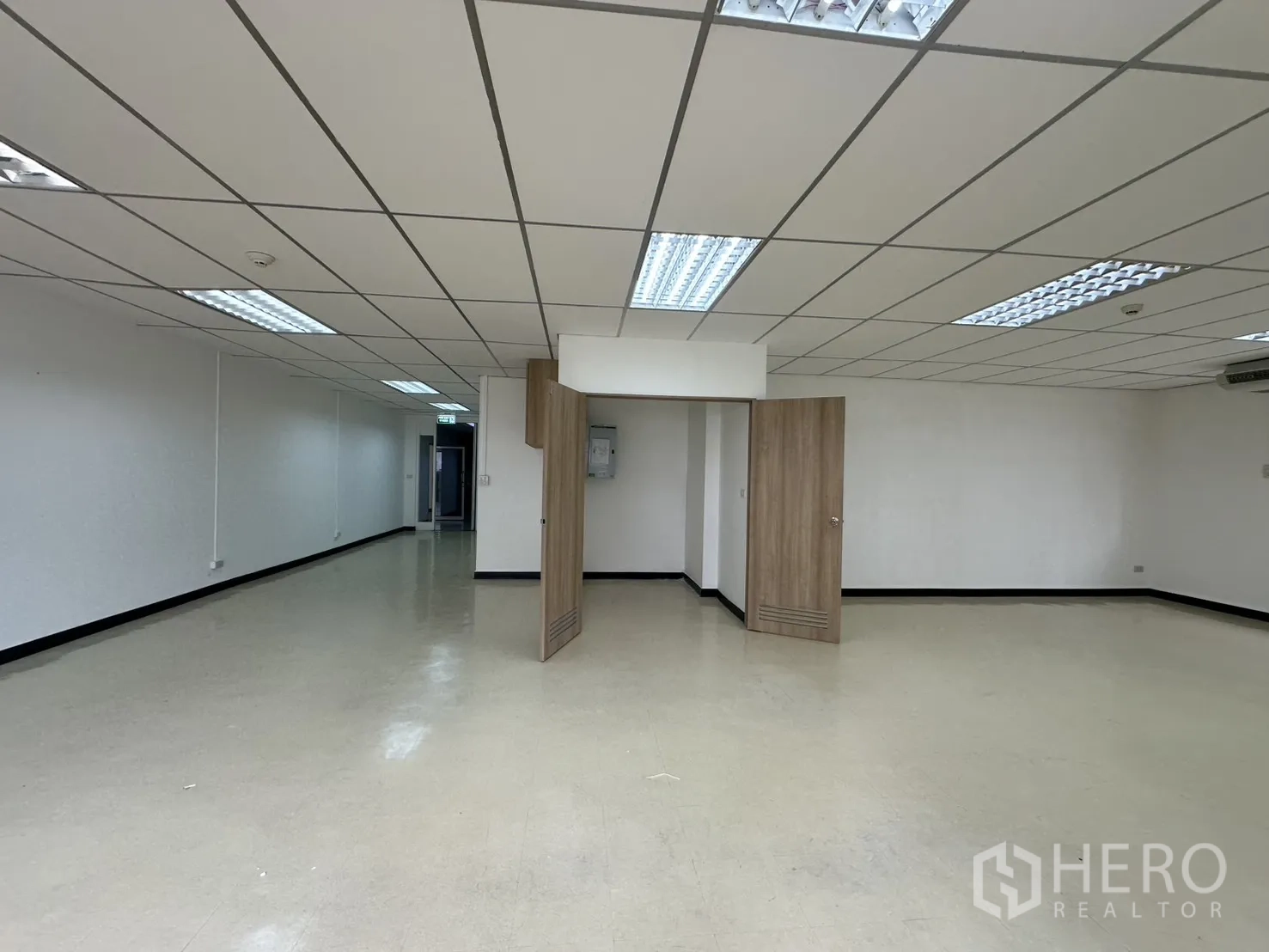 Office Space for rent in Pathum Wan, Bangkok - Spacious office floor with folding wooden partition doors, light vinyl flooring, and ceiling lights.