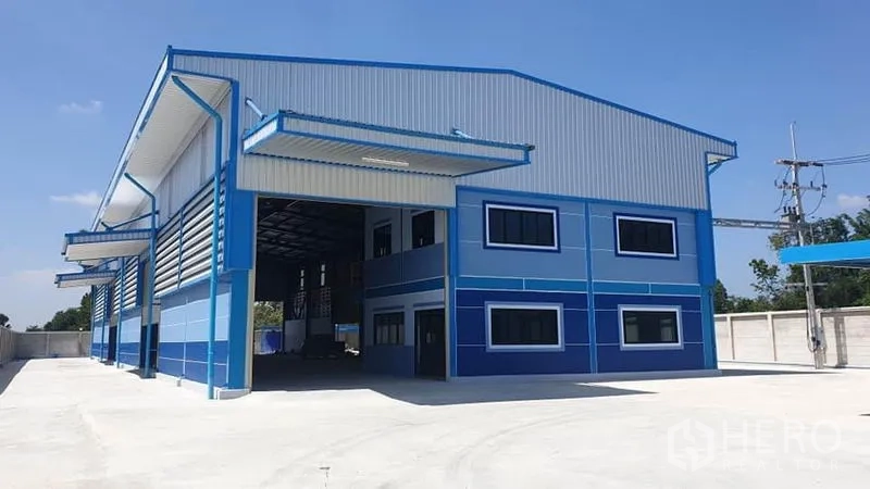 Factory for rent or sale in Phanat Nikhom, Chon Buri - Front facade of the factory with office windows and covered loading bays.