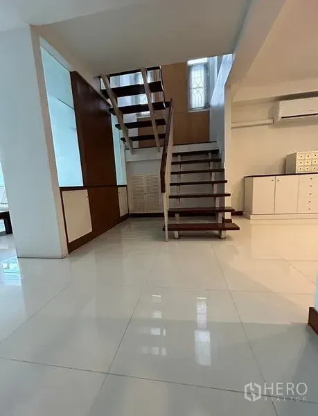 Home Office for rent in Suan Luang, Bangkok - Bright foyer with floating wooden staircase and glossy tile floors.
