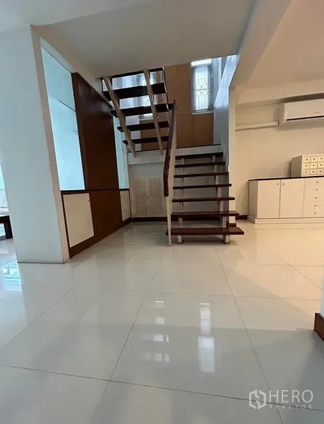 Home Office for rent in Suan Luang, Bangkok - Bright foyer with floating wooden staircase and glossy tile floors.