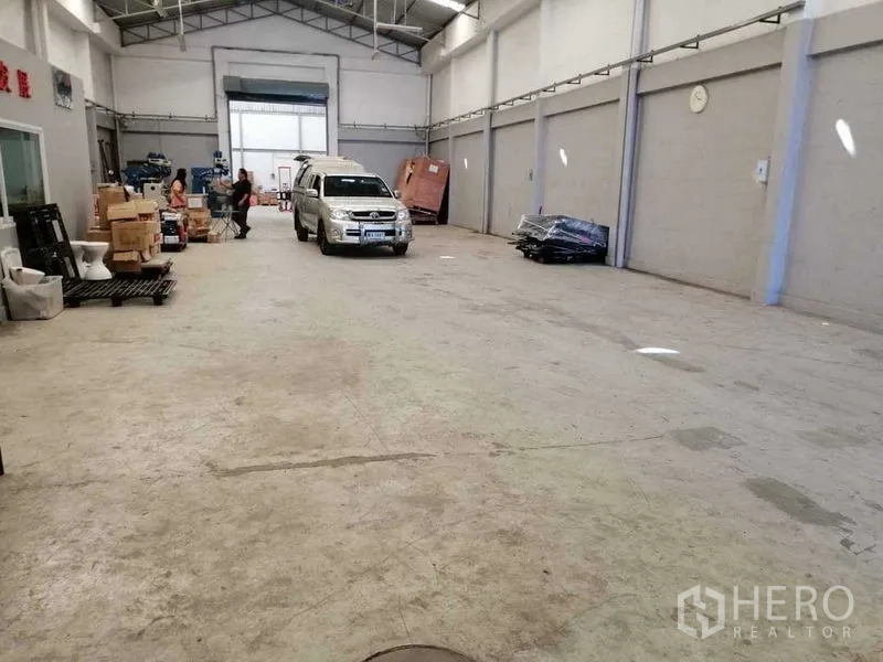 Warehouse for rent in Samut Prakan - Warehouse interior showing wide clear span and parking space for a pickup truck.