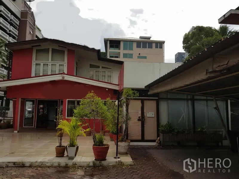 Retail Space for rent in Watthana, Bangkok - Two-storey red retail building with courtyard and potted plants in Watthana, Bangkok.