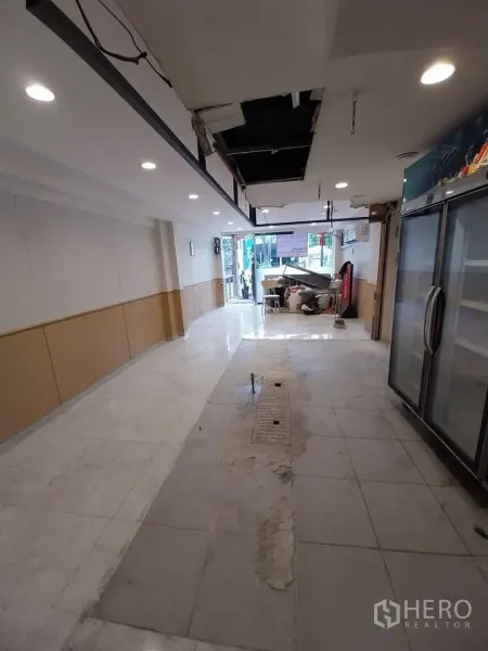 店屋 出租或出售在Watthana, Bangkok - 室内望向门口，天花在施工，地面排水沟适合厨房。