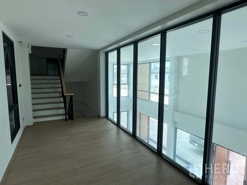 Warehouse for sale in Lam Luk Ka, Pathum Thani - Second-floor corridor with full-height glass overlooking double-volume lobby and stairs.