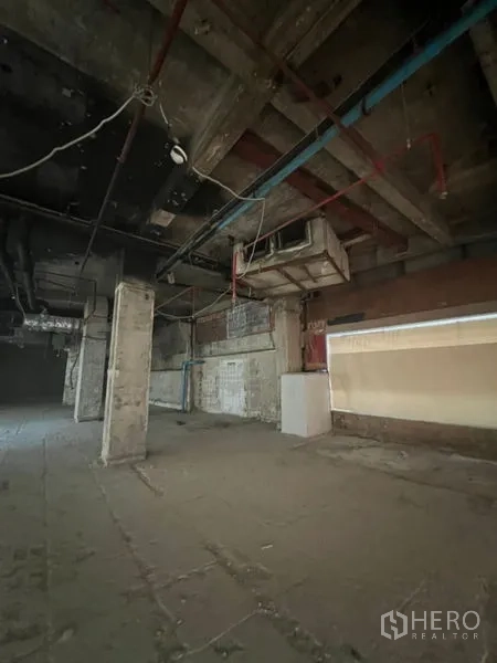 Retail Space for rent in Bang Rak, Bangkok - Open-plan shop space showing exposed pipes, columns, and high ceilings.