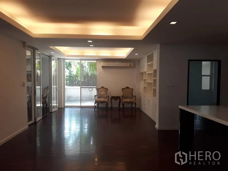 Detached House for rent in Watthana, Bangkok - Open-plan living area with cove lighting, sliding doors to terrace and built-in shelving