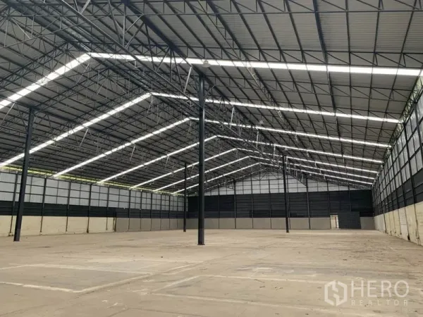 Factory for rent in Chon Buri - Expansive clear-span factory floor with steel columns, ventilated wall panels and bright roof lighting.