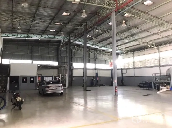 Factory for rent in Bang Bua Thong, Nonthaburi - High-clearance production area with steel truss roof and polished floor.
