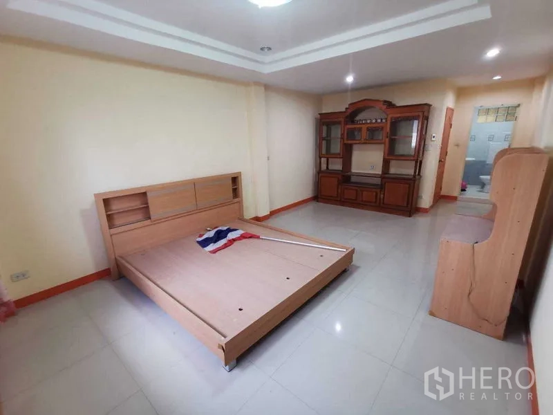 Shophouse for rent in Suan Luang, Bangkok - Bright bedroom with light tiles, wooden cabinet and recessed ceiling.
