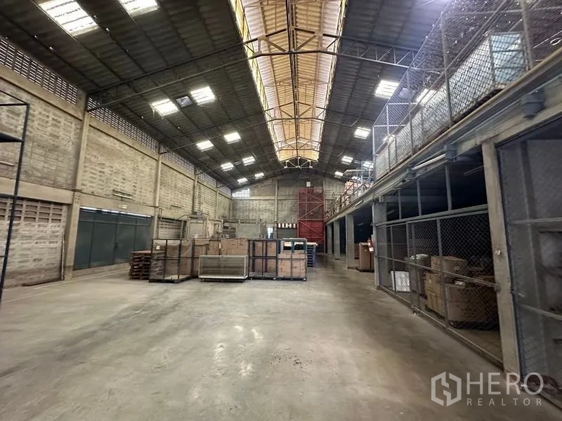 Factory for rent in Lam Luk Ka, Pathum Thani - Open storage bay with ridge skylight, tall roof, and stacked crates.
