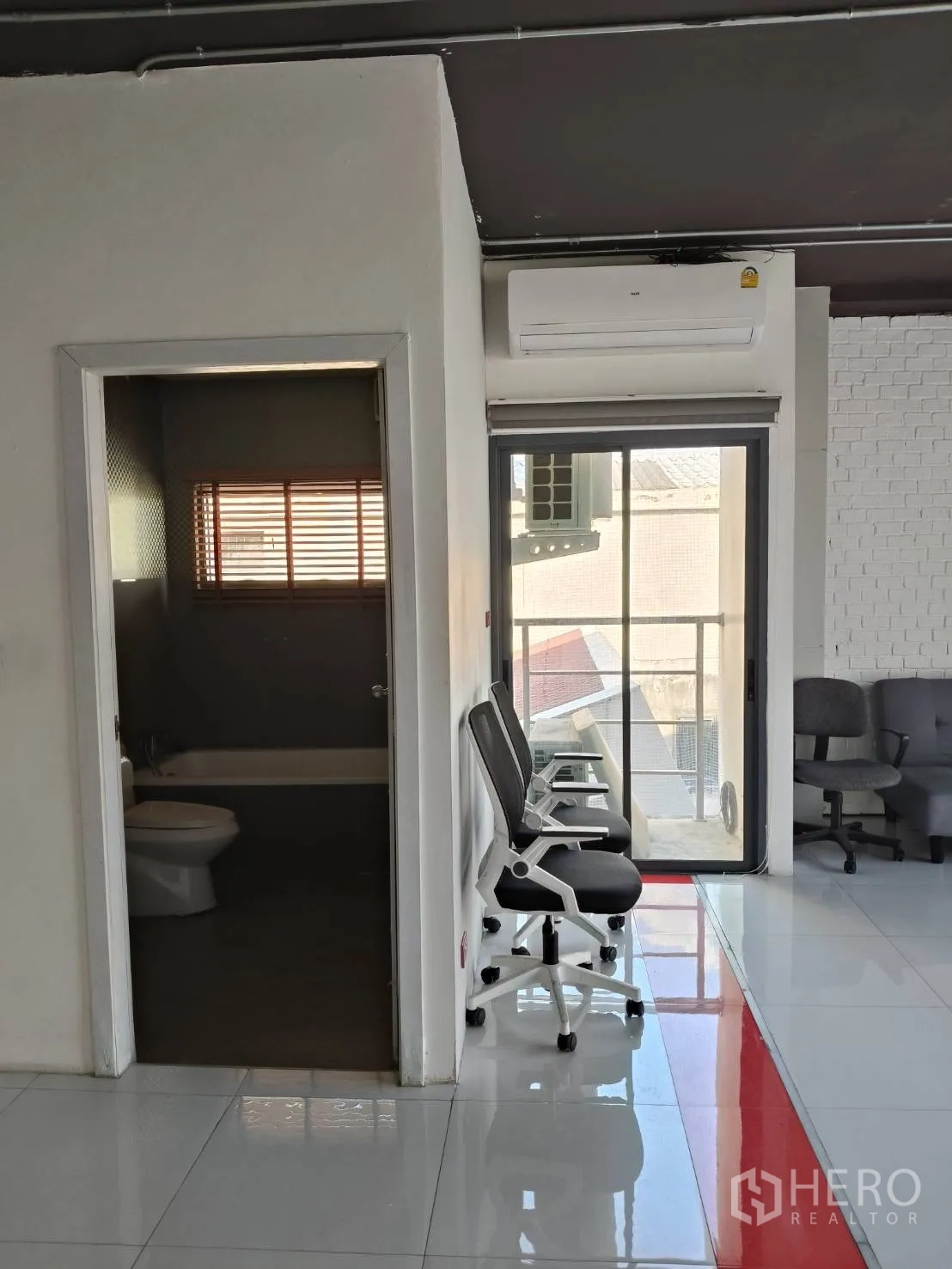 Office Space for rent in Khlong Toei, Bangkok - Small room with glass door to balcony and sheer curtain, wood-look flooring throughout.