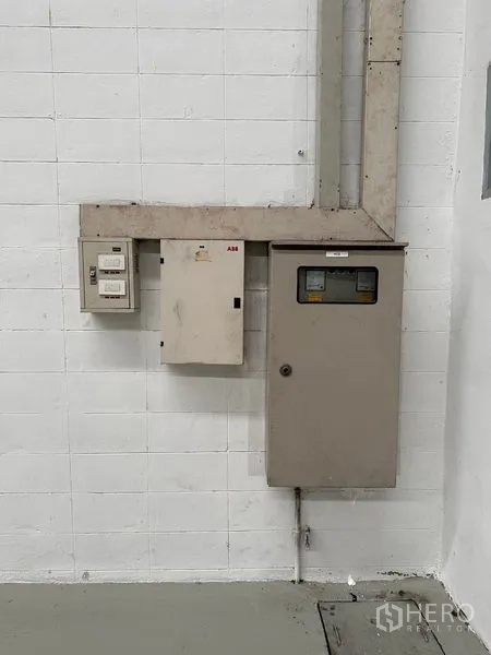 Factory for rent in Si Racha, Chon Buri - Electrical control panel and meters mounted on an interior factory wall.