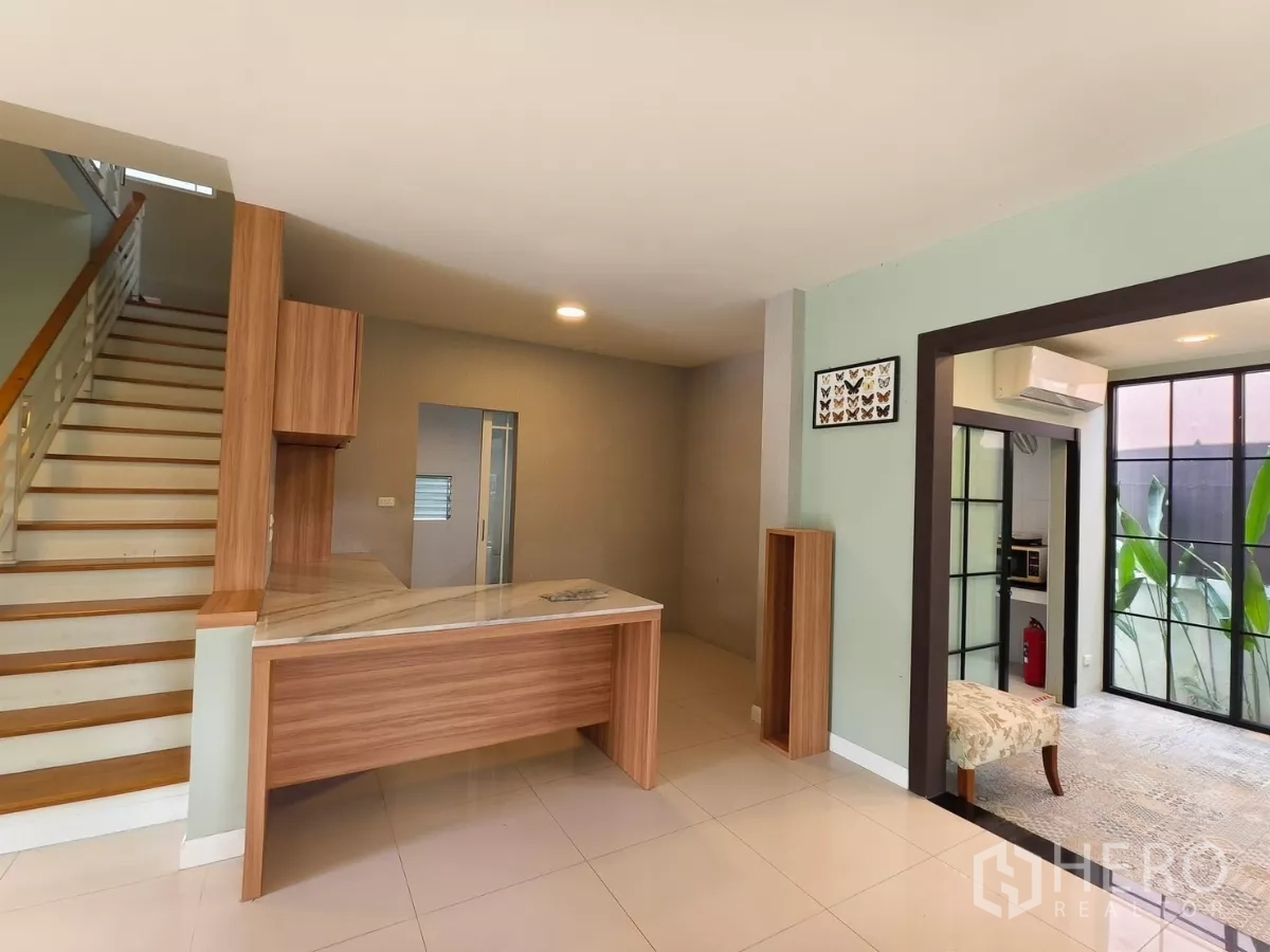 Detached House for rent in Bang Kapi, Bangkok - Landing area with built‑in wood counter beside stairs and door to kitchen.