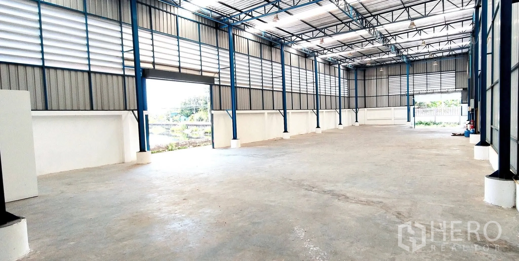 Warehouse for rent in Bang Phli, Samut Prakan - Open warehouse interior with steel structure, tall roof and concrete floor.