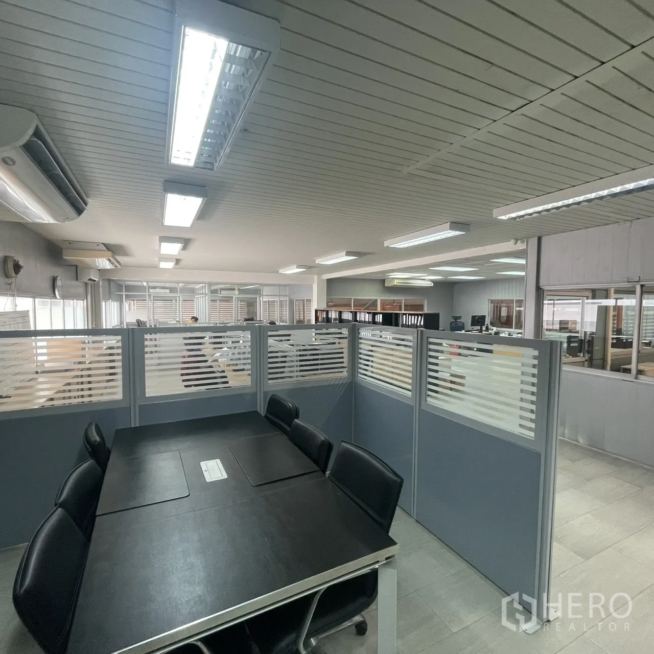 Factory for rent in Khlong Toei, Bangkok - Meeting table and partitioned workstations inside the bright office area.