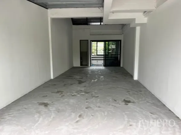 Retail Space for rent in Watthana, Bangkok - Unfurnished 45 sqm retail unit with white walls, high ceiling, concrete floor, and rear windows plus a bathroom door.