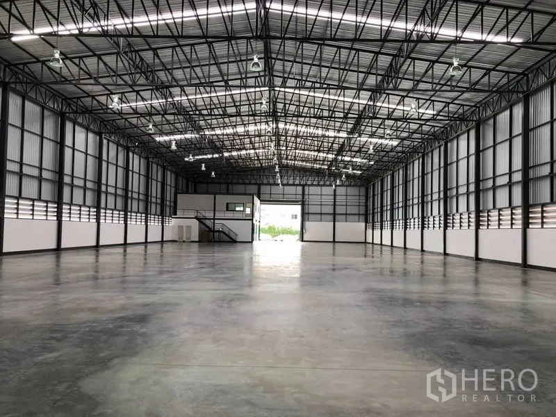 Warehouse for rent in Bang Phli, Samut Prakan - Spacious warehouse interior with high steel truss roof, polished concrete floor and high-bay lighting.