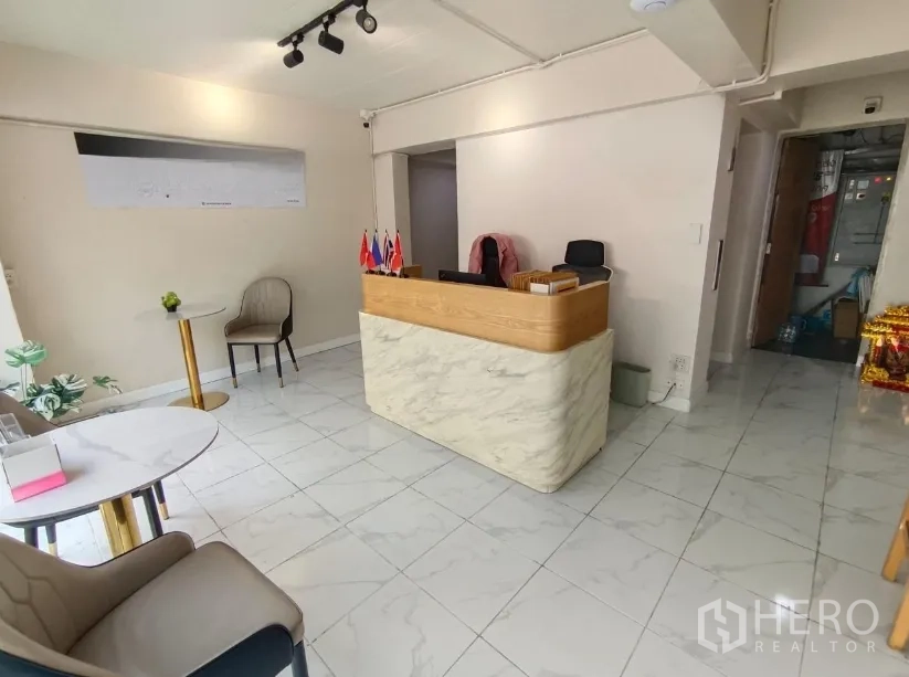 Shophouse for rent in Watthana, Bangkok - Bright reception area with marble-look counter, tiled floor and seating.