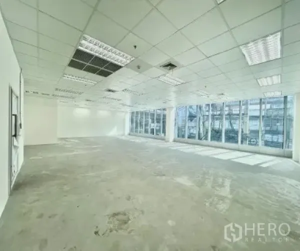 Office Space for rent in Khlong Toei, Bangkok - Bright corner office with wraparound glazing and natural light across the open space.