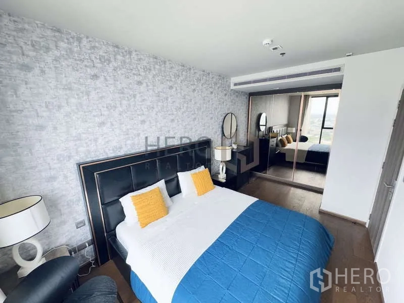 Condominium for rent - Bedroom with mirrored wardrobe reflecting natural light and skyline views.
