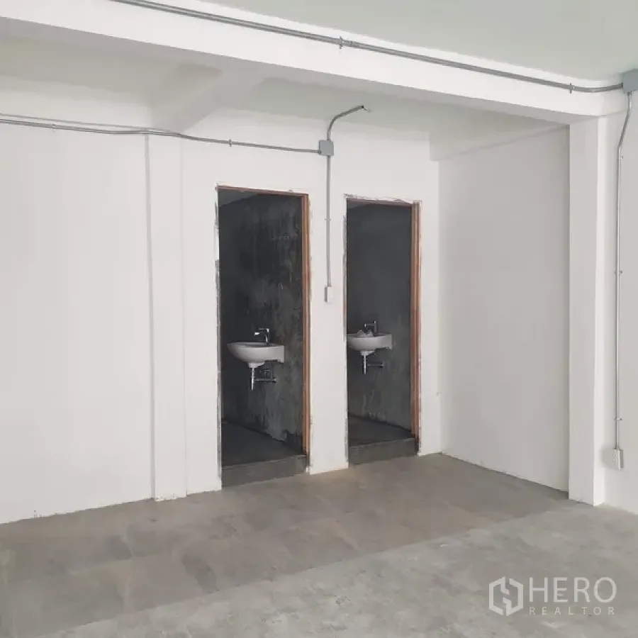 带办公室的家 出租在Khlong Toei, Bangkok - 两间极简风卫生间，挂墙式洗手盆与水泥清水墙面。