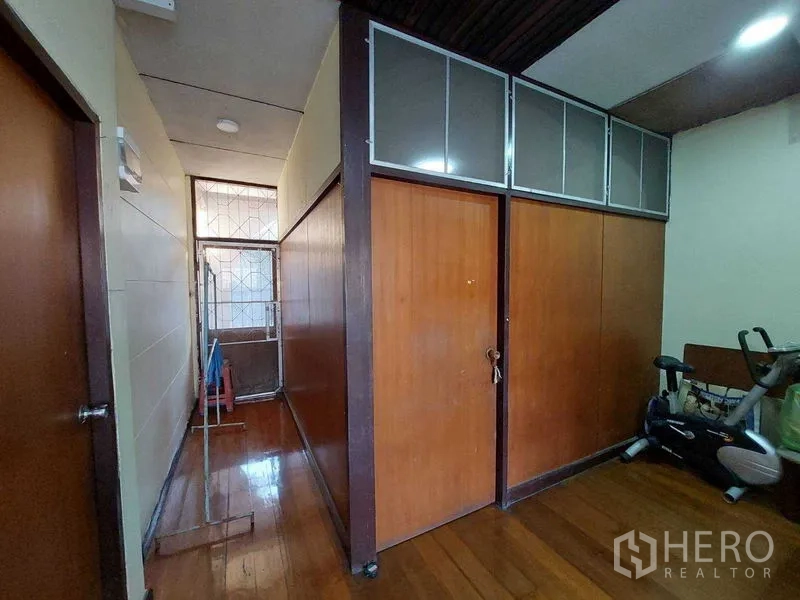 Townhouse for sale - Upstairs corridor with wooden doors, transom windows, and glossy timber flooring.