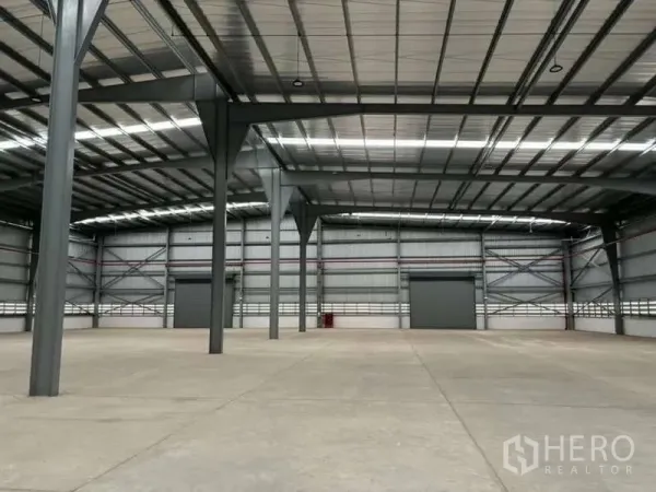 Warehouse for rent in Nikhom Phatthana, Rayong - High-clearance steel-frame warehouse interior with polished concrete floor and large shutter doors