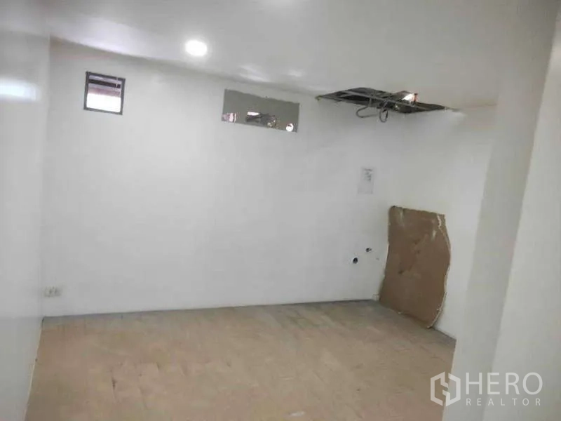 Shophouse for sale in Phra Khanong, Bangkok - Back room with small windows and an exposed ceiling access panel.
