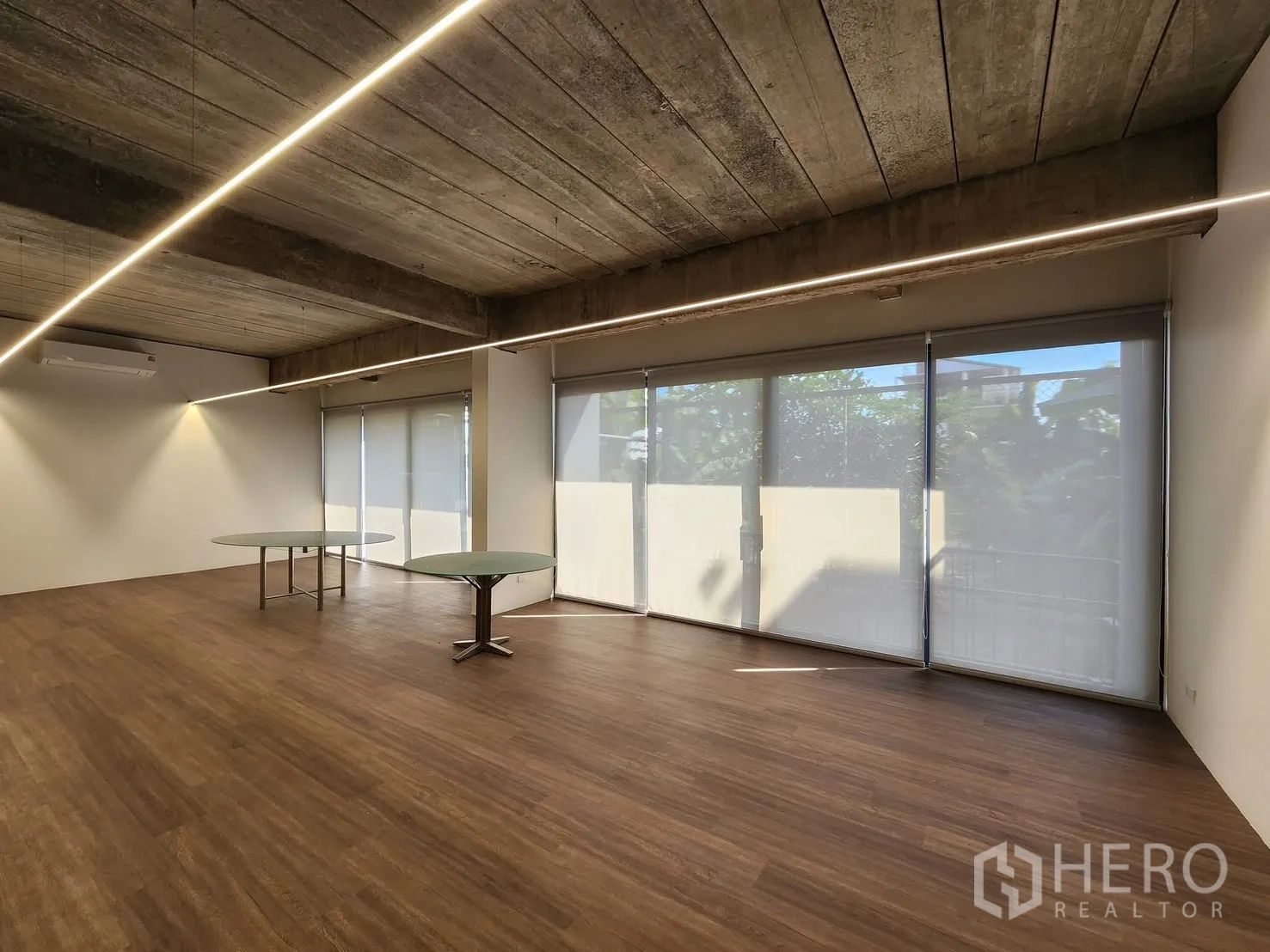 Home Office for rent in Chatuchak, Bangkok - Open meeting space with two round tables and shaded floor-to-ceiling windows.