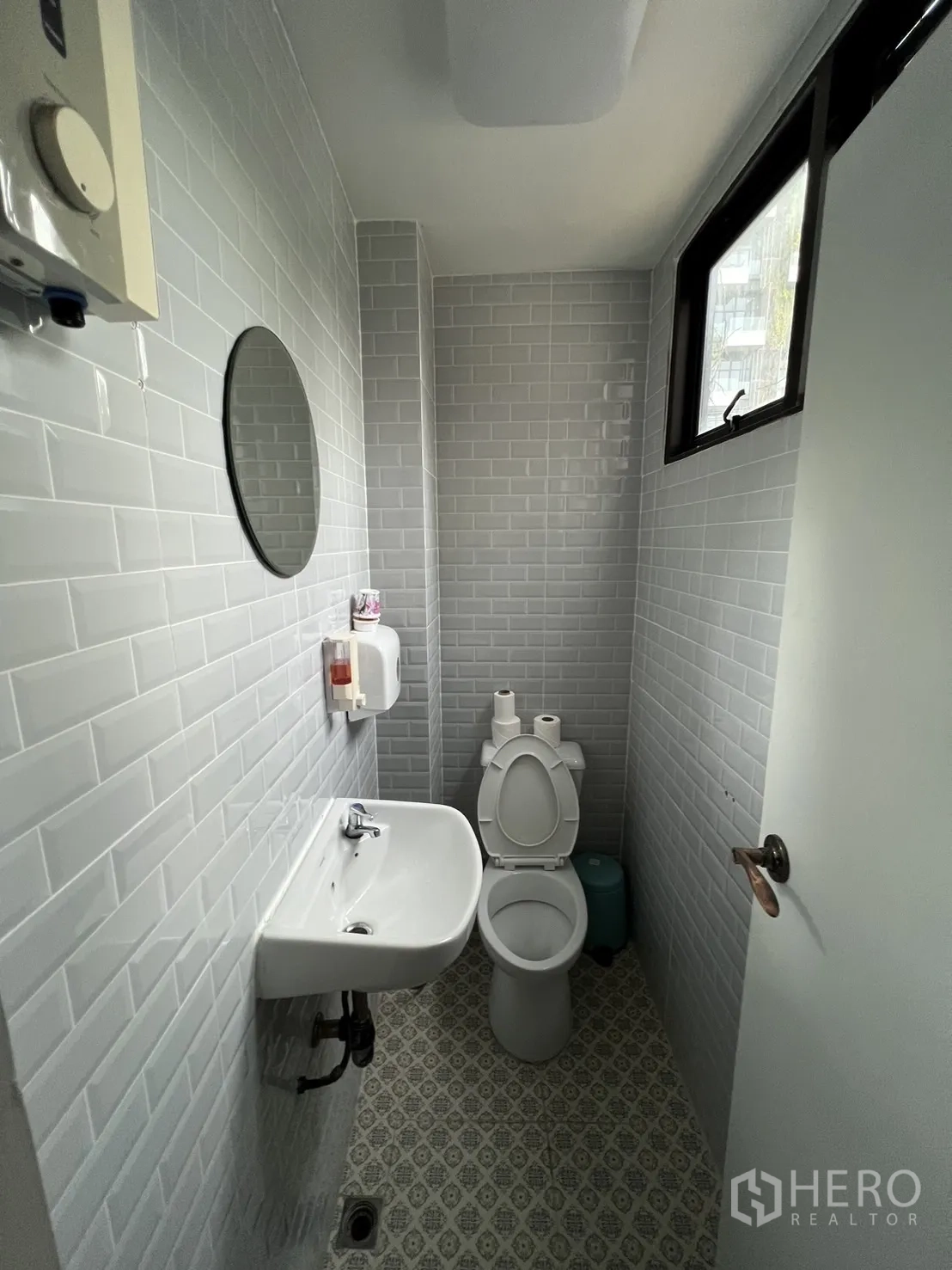 Shophouse for rent or sale in Watthana, Bangkok - Bright bathroom with frosted window, white tiles and sink.