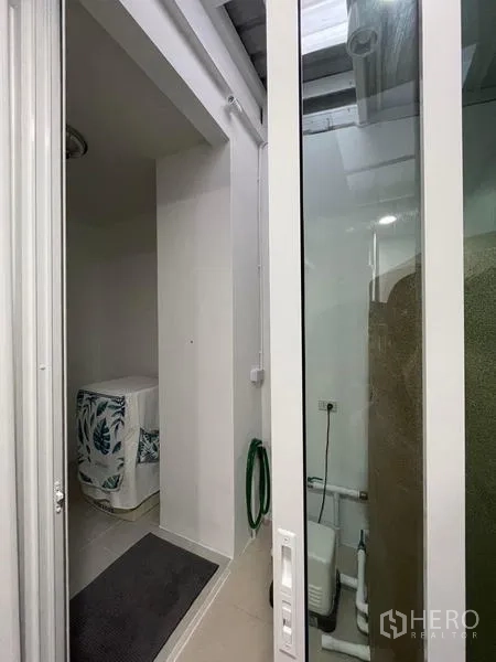 Townhouse for rent in Suan Luang, Bangkok - Covered laundry and service zone with washing machine nook and storage tank.