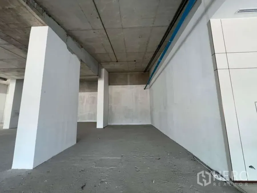 Retail Space for rent - Shell retail unit with high ceiling, white walls, exposed concrete floor and columns, ready for fit-out.