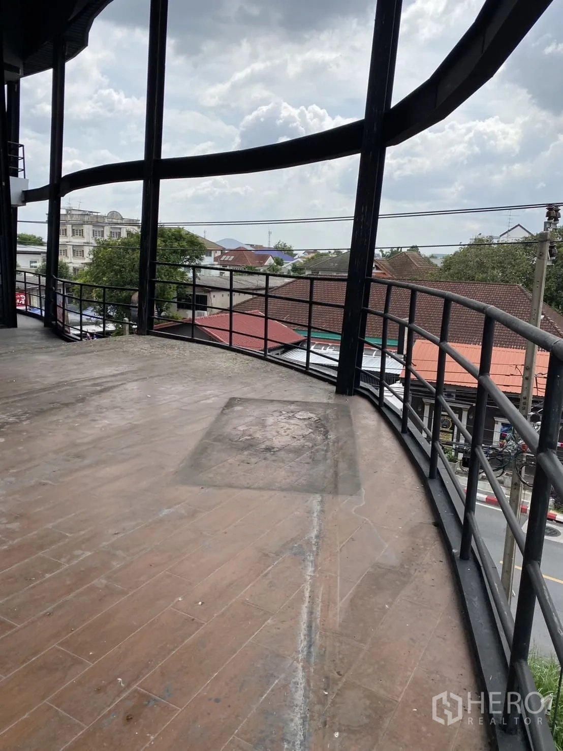 Showroom for rent in Lat Phrao, Bangkok - Spacious curved balcony terrace with metal railings overlooking the neighborhood.