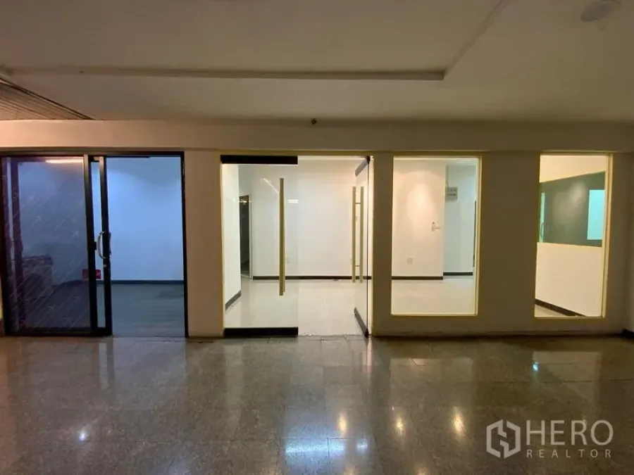 办公空间 出租在Watthana, Bangkok - 位于建筑走道的玻璃门面办公室入口，带滑动门与展示窗