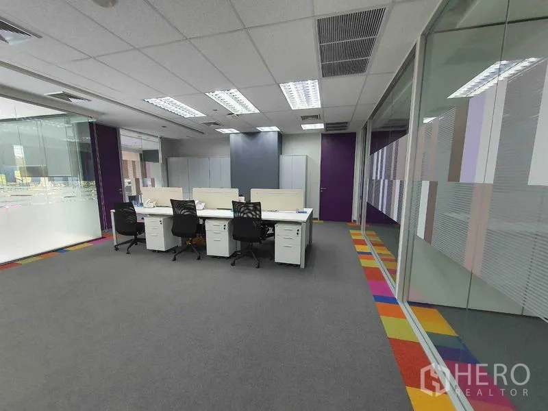 Office Space for rent in Ratchathewi, Bangkok - Team work area with cluster desks, bright ceiling lights, and glass partitions.