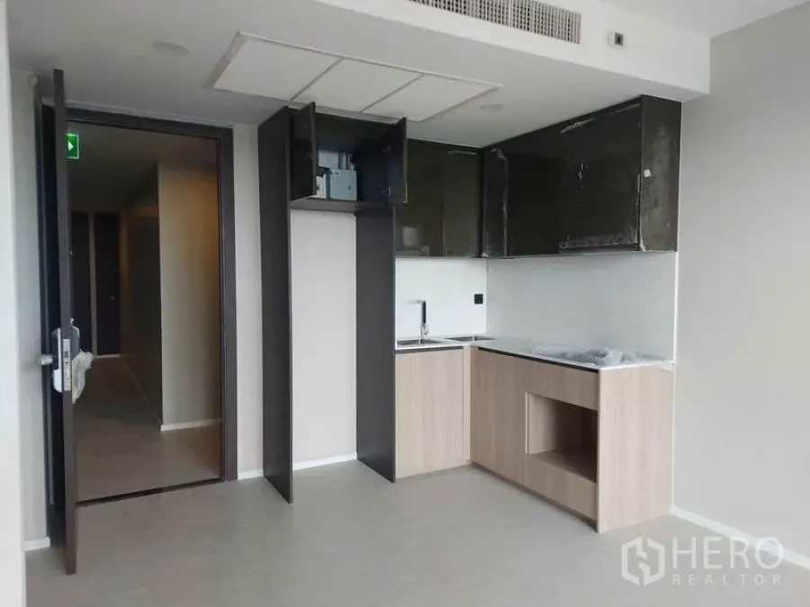 Condominium for sale in Pathum Wan, Bangkok - L-shaped pantry kitchen with overhead cabinetry and space for appliances.