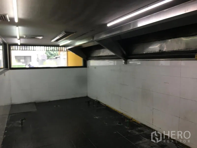Retail Space for rent in Khlong Toei, Bangkok - Commercial back-of-house room with stainless ventilation hoods and high windows, ideal for a kitchen setup.