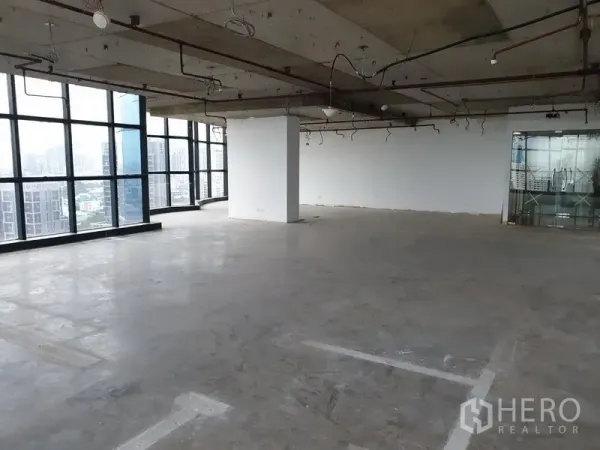 Office Space for rent in Watthana, Bangkok - Spacious unfinished office floor with exposed ceiling, glass walls, and city views.