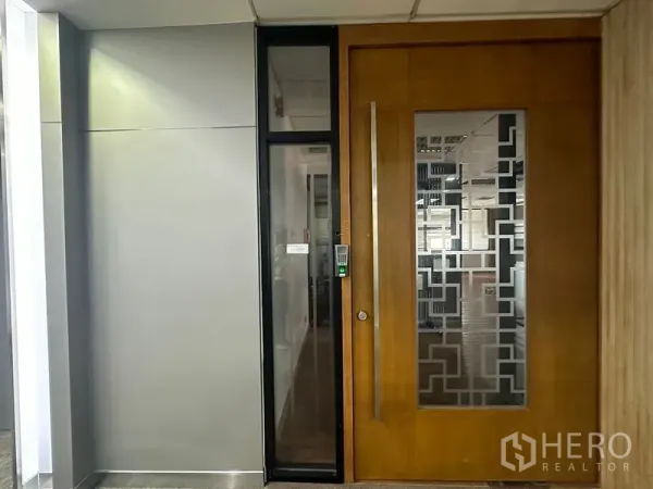 Office Space for rent in Bang Rak, Bangkok - Secure office entrance with a large wooden door, frosted geometric glass panel, and keycard access beside a slim glass sidelight.