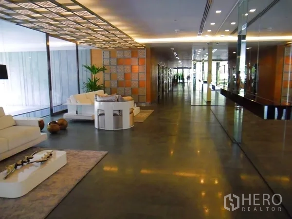 Condominium for rent or sale in Watthana, Bangkok - Stylish condominium lobby with lounge seating and mirrored walls.