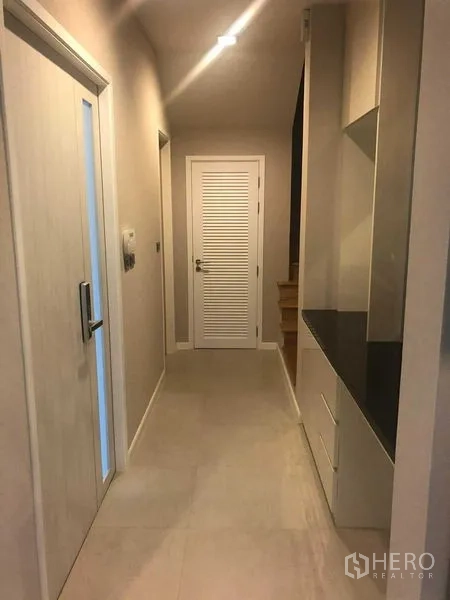Detached House for rent or sale in Bang Kapi, Bangkok - Interior hallway with storage counter and doors leading to rooms.