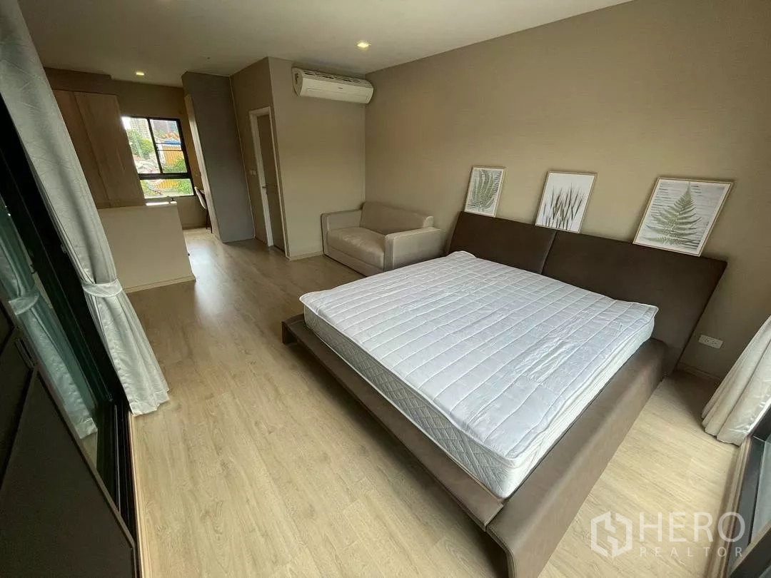 Townhouse for rent in Suan Luang, Bangkok - Angle of the master suite showing sleeping area, sofa, work nook and door to ensuite.