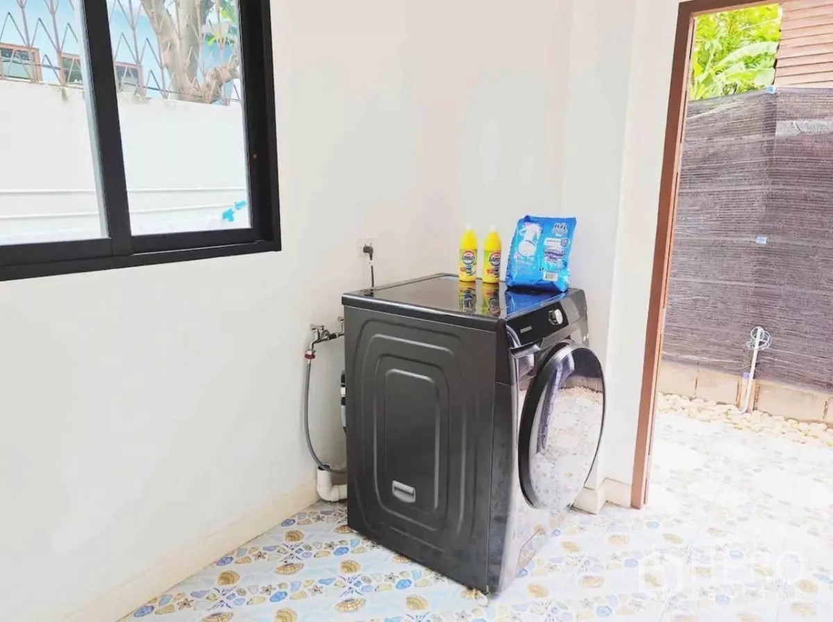 Detached House for rent in Phaya Thai, Bangkok - Laundry area with front-load washer, utility sink and access to a small patio.